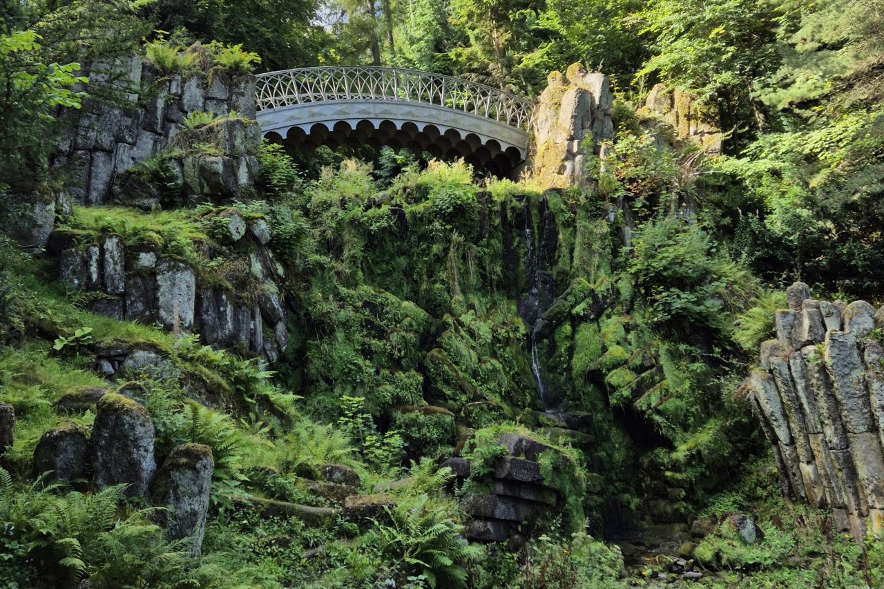 Weiße Brücke im Grünen als Symbol für Mediation und Verständigung